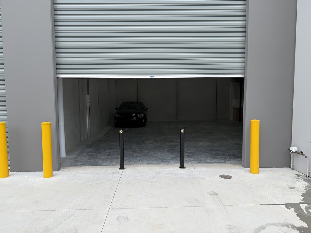 The same warehouse bay with two removable Key Bollards installed across the entrance and the site cleaned up